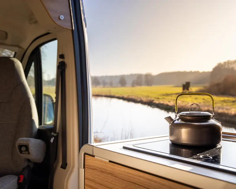 Théière sur une taque de cuisson dans un camping-car